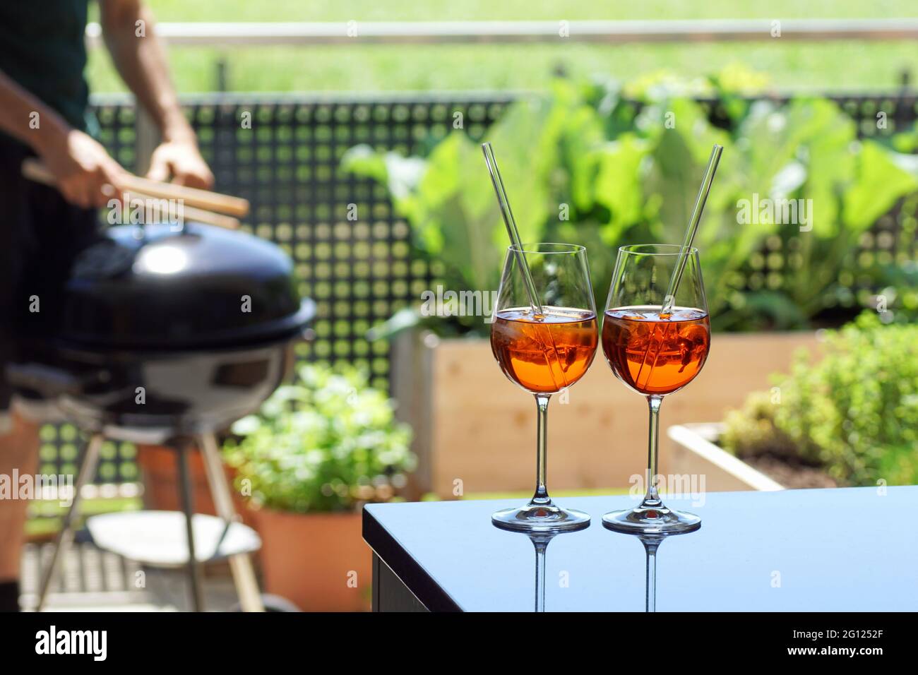 due aperitivi estivi (spritz veneziano, aperol) su un tavolo su un balcone giardino Foto Stock
