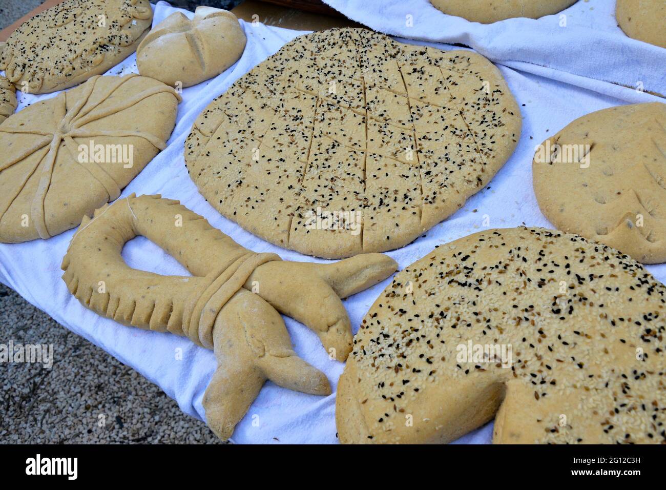 Una selezione di pane cipriota tradizionale fatto a mano pronto per la cottura nel forno a pietra Foto Stock