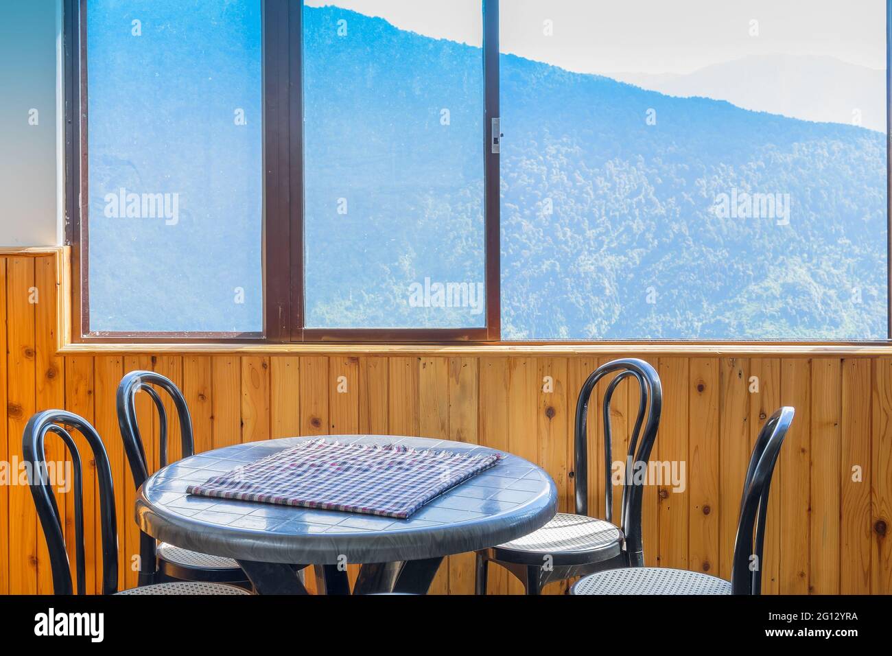 Tavolo, sedie e finestra con vista sulla montagna esterna. Sikkim, bengala Occidentale, India. Foto Stock