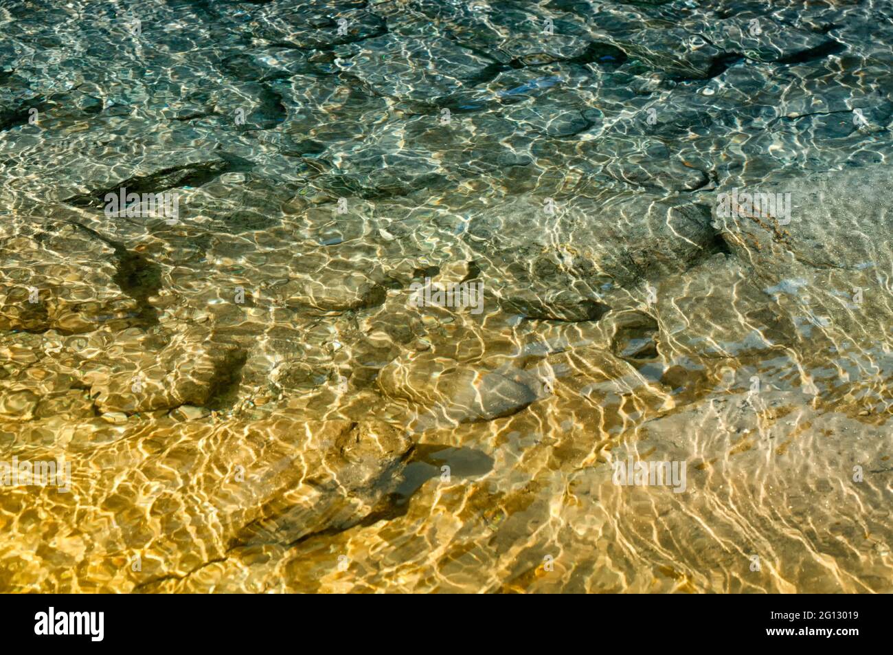 Riflesso della luce del sole sulle pietre sottomarine e rocce del fiume Reshi. Reshi è uno dei fiumi più famosi del Sikkim che scorre attraverso le pietre Foto Stock