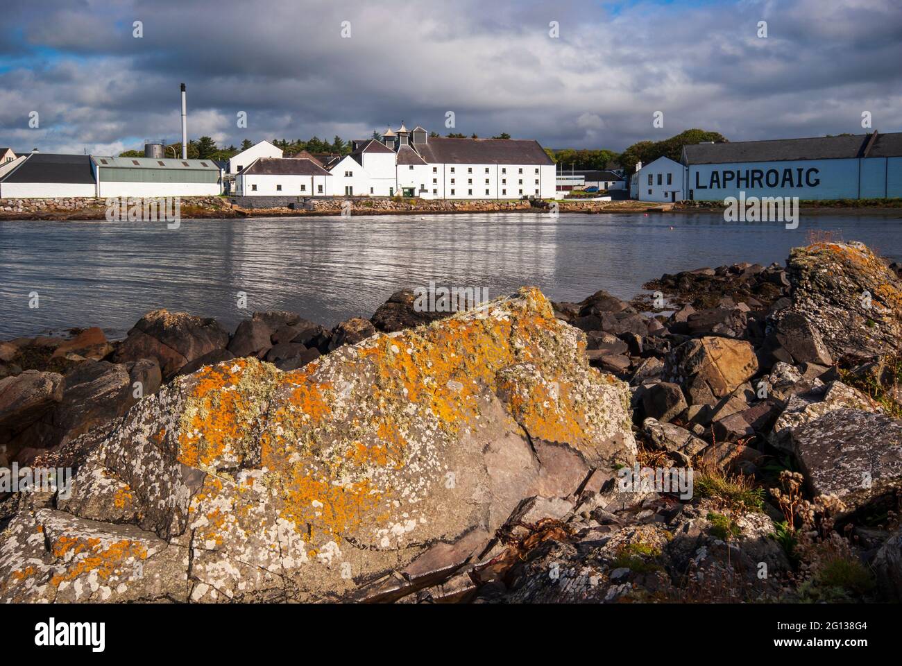 Una vista attraverso la piccola baia agli edifici della distilleria di whisky Laphroaig sull'Isola di Islay in Scozia. Foto Stock