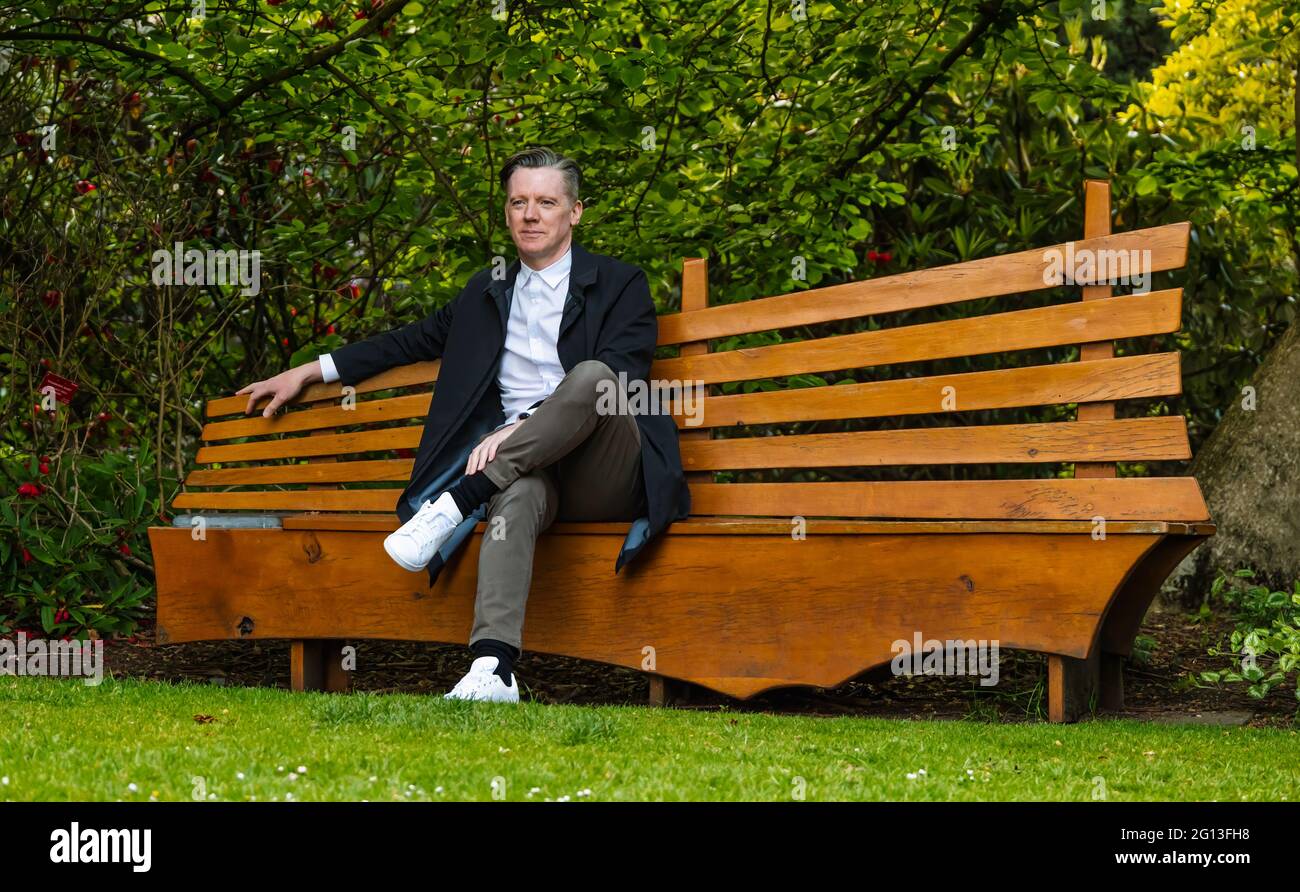 Fergus Linehan, direttore del Festival, al lancio del Festival Internazionale di Edimburgo seduto in panchina nel Royal Botanic Garden, Scozia, Regno Unito Foto Stock