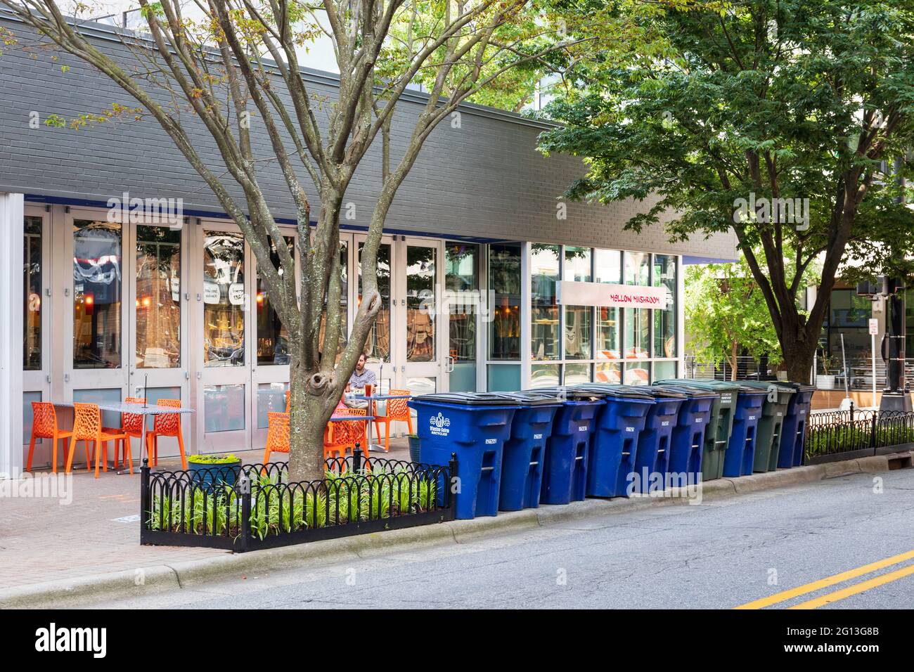 WINSTON-SALEM, NC, USA-1 GIUGNO 2021: Un ristorante Mellow Mushroom, con linea di lattine blu di fronte al marciapiede. Foto Stock