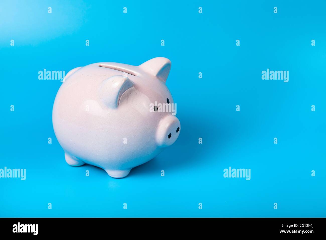 Pink porcellino banca su sfondo blu. Accumulo di denaro. Foto Stock