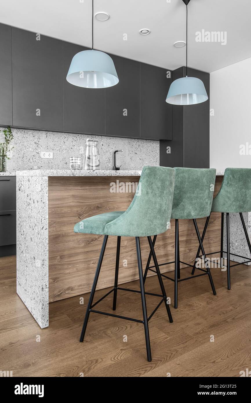Bancone bar con tre sgabelli da bar e piano cucina con effetto pietra  grigia all'interno dell'appartamento Foto stock - Alamy
