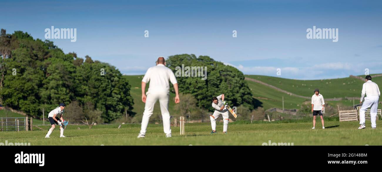 Wensleydale, Regno Unito. 04 giugno 2021. 4 giugno 2021 - Hawes, North Yorkshire - cricket Village in quello che deve essere uno dei più scenici piccoli terreni come Hawes pipistrello sul loro terreno di casa a Haylands sulle rive del fiume Ure. Credit: Wayne HUTCHINSON/Alamy Live News Foto Stock