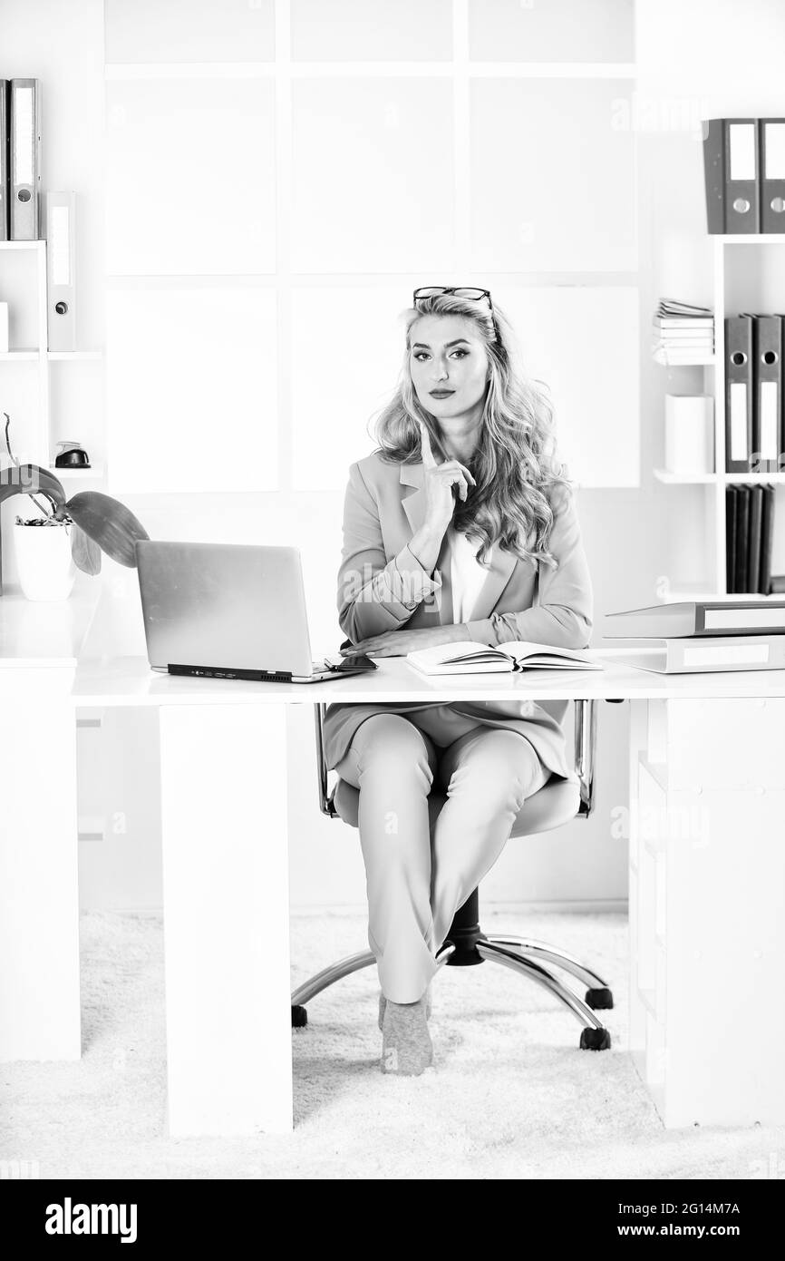 Esplora le guide, gli articoli e le risorse utili per le donne nel mondo degli affari. Ragazza con computer portatile in ufficio. Tecnologia digitale. Navigare in internet Foto Stock