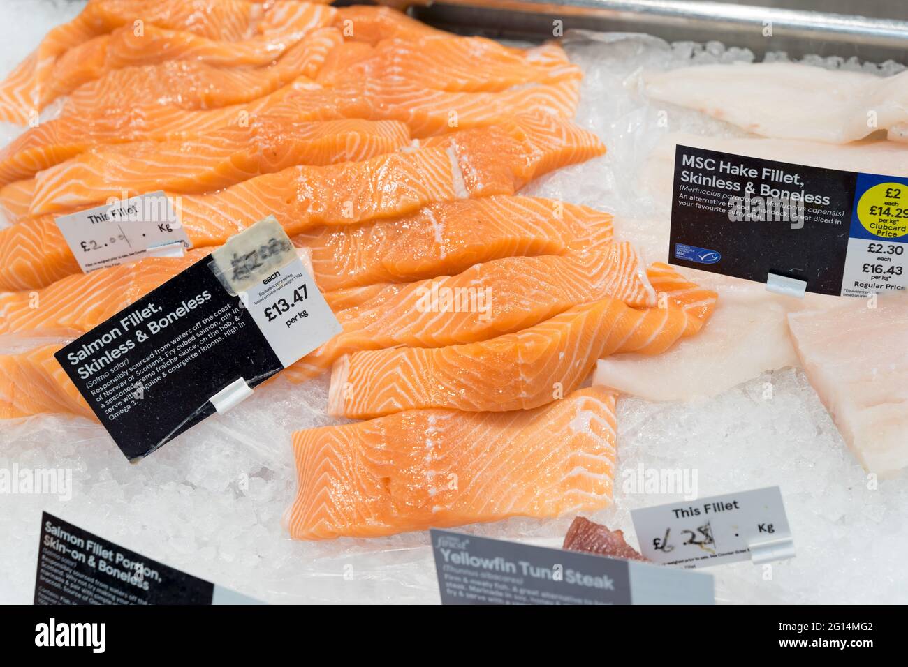 Pesce fresco crudo, filetto di salmone in vendita, taglio pronto, banco Tesco Supermarket Fishmonger, Inghilterra, UK Foto Stock