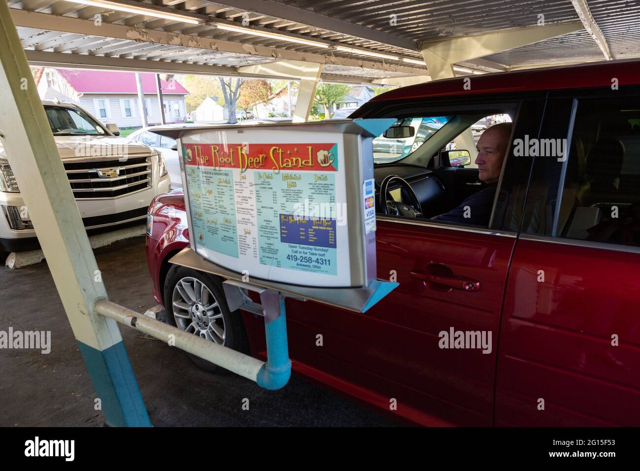Un uomo effettua la sua selezione dal menu drive-in mentre si siede nella sua auto al Root Beer Stand ad Anversa, Ohio, USA. Foto Stock
