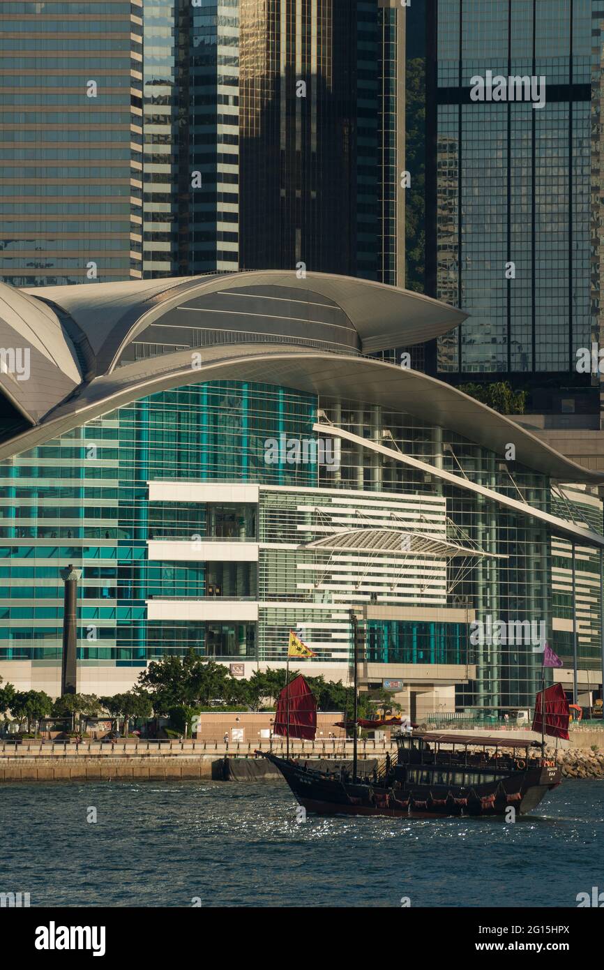 L'Aqua Luna, una replica della spazzatura cinese usata per le crociere, passa davanti al Centro Convegni ed Esposizioni e agli alti edifici di WAN Chai, Hong Kong Foto Stock