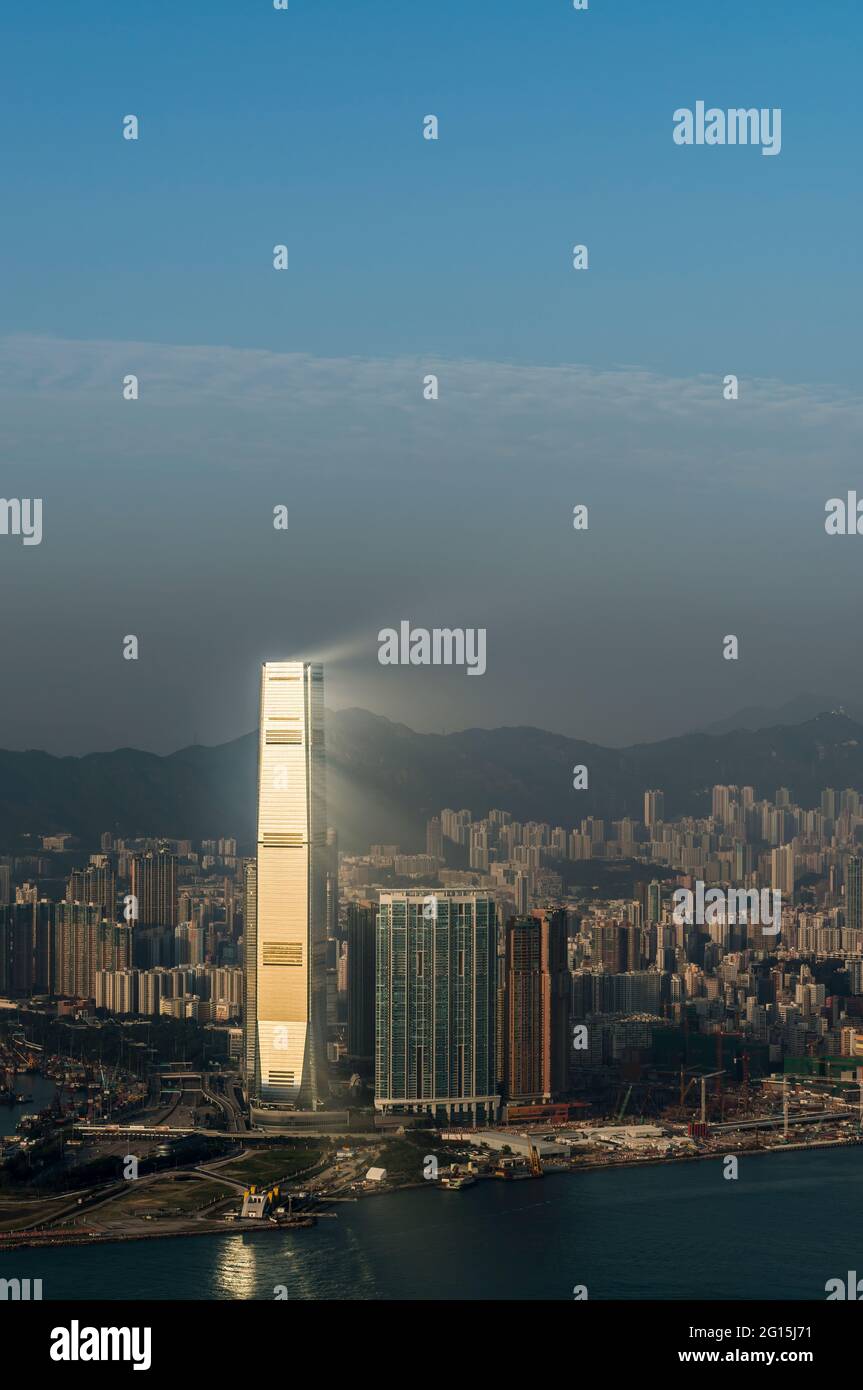 La luce del sole del tardo pomeriggio si è riflessa sulla façade facciata di vetro dell'ICC, l'edificio più alto di Hong Kong, visibile a causa della foschia atmosferica, West Kowloon Foto Stock
