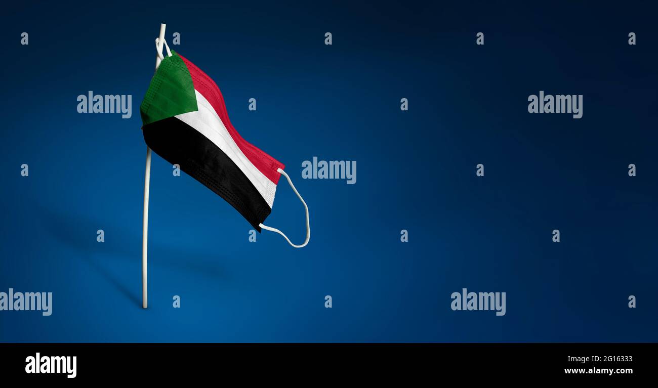 Bandiera ondulata del Sudan dipinta su maschera medica sul palo. Concetto del banner della lotta contro l'epidemia coronavirus COVID-19. Spazio di copia Foto Stock