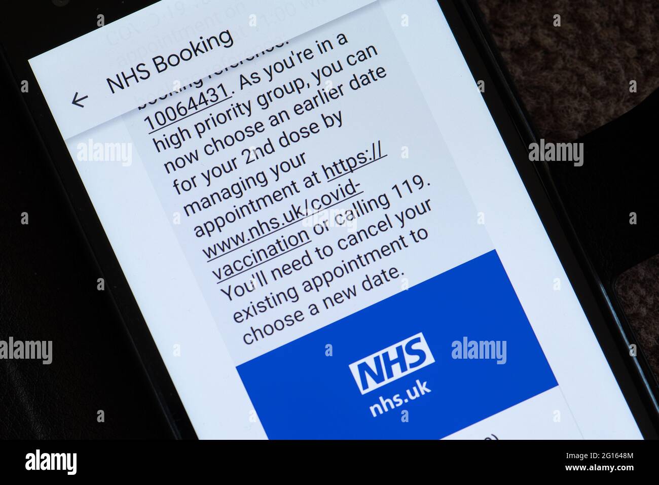 Messaggio di testo da parte dell'NHS che consiglia di prenotare un appuntamento precedente per la seconda vaccinazione di covidio come nel gruppo ad alta priorità (oltre 50 anni), Regno Unito, giugno 2021 Foto Stock