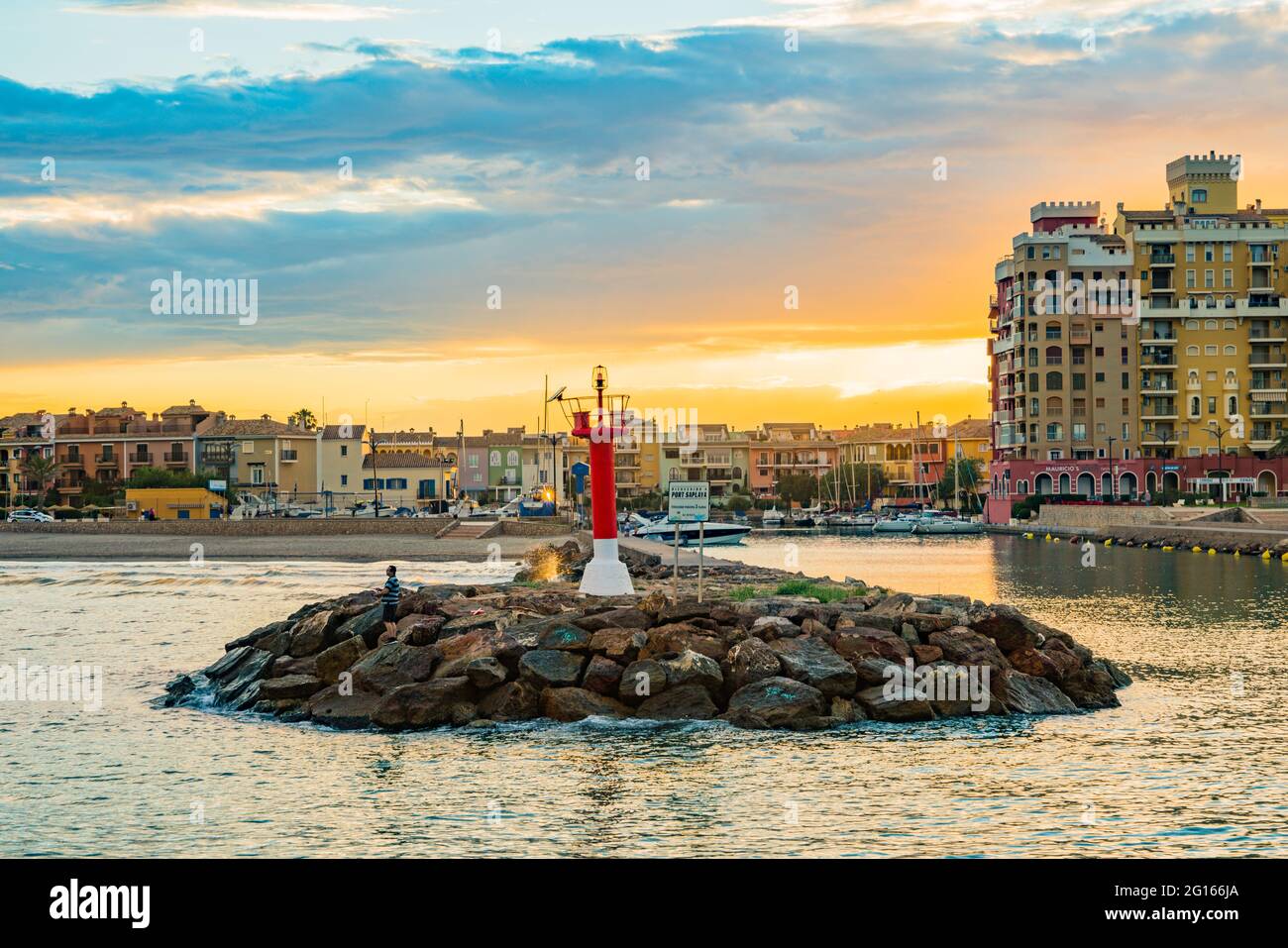 Vista del faro all'ingresso della baia di Port Sauslaya durante un tramonto colorato. Valencia Foto Stock
