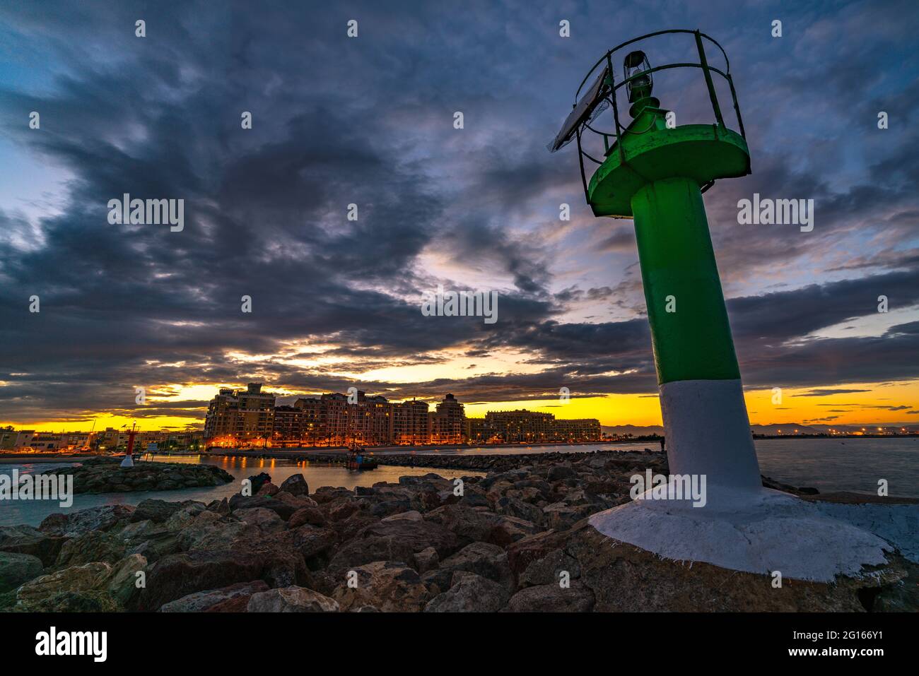 Vista del faro all'ingresso della baia di Port Sauslaya durante un tramonto colorato. Valencia Foto Stock