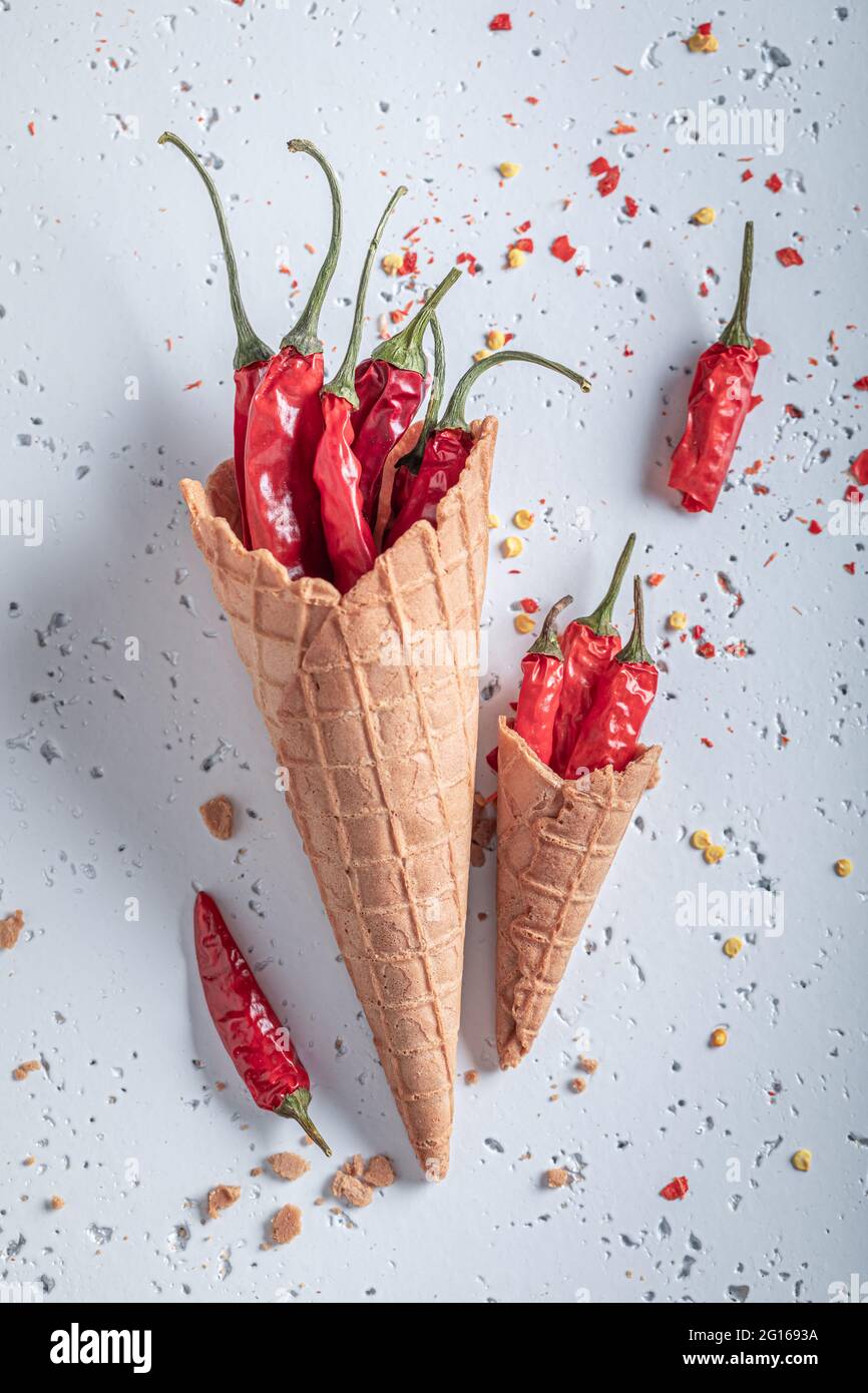 Gelato piccante. Cono gelato e peperoncini. Strani sapori di gelato. Nuovi sapori di gelato. Foto Stock