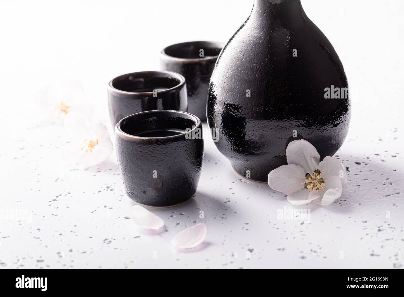 Sake giapponese in ceramica nera. Sake tradizionalmente servito in  ceramica. Ceramica nera su una pietra bianca Foto stock - Alamy