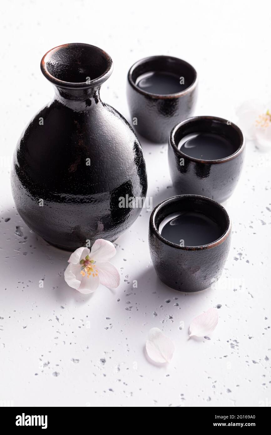 Sake giapponese in ceramica nera. Abitudine giapponese di bere alcol.  Ceramica nera su una pietra bianca Foto stock - Alamy