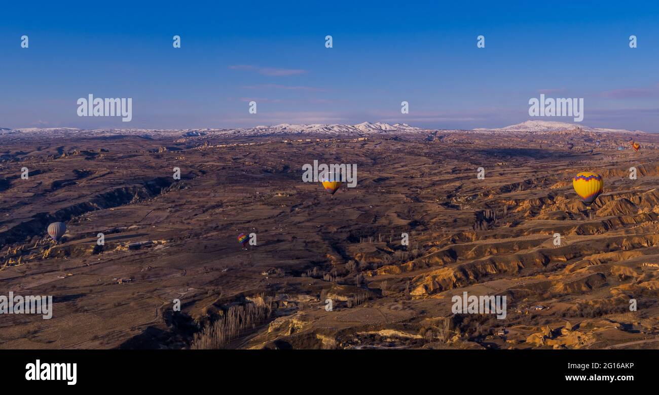Göreme, Cappadocia, Turchia - 19 marzo 2021 - bella vista aerea di mongolfiere che volano su paesaggi incredibili con camini delle fate Foto Stock