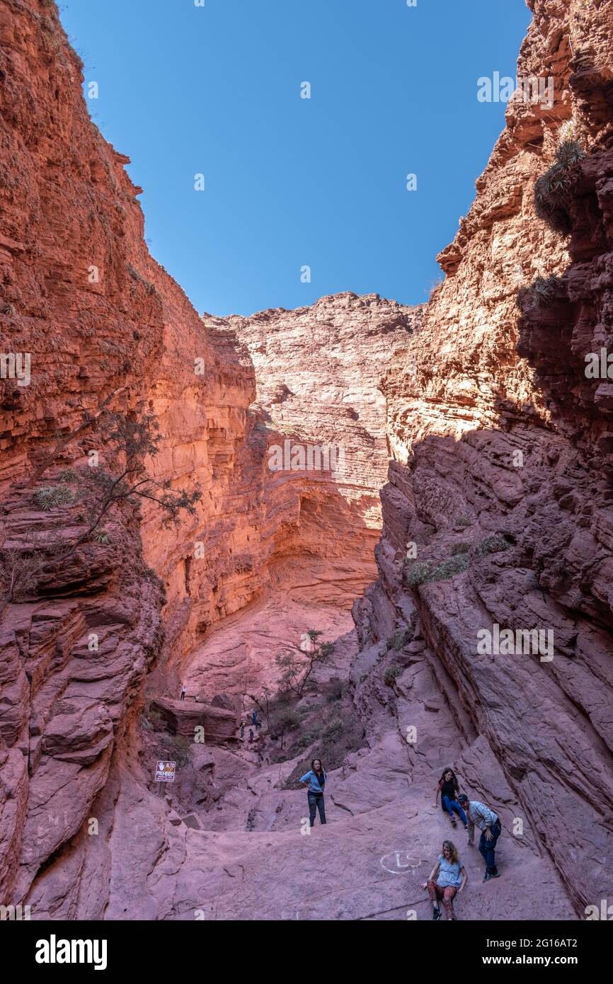 I turisti esplorano la Gola del Diavolo (Garganta del Diablo) una gola di roccia rossa sulla strada tra Salta e Cafayate nella provincia di Salta, Argentina Foto Stock