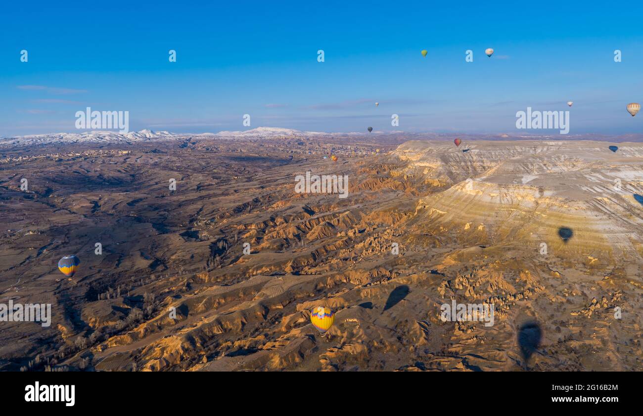Göreme, Cappadocia, Turchia - 19 marzo 2021 - bella vista aerea di mongolfiere che volano su paesaggi incredibili con camini delle fate Foto Stock
