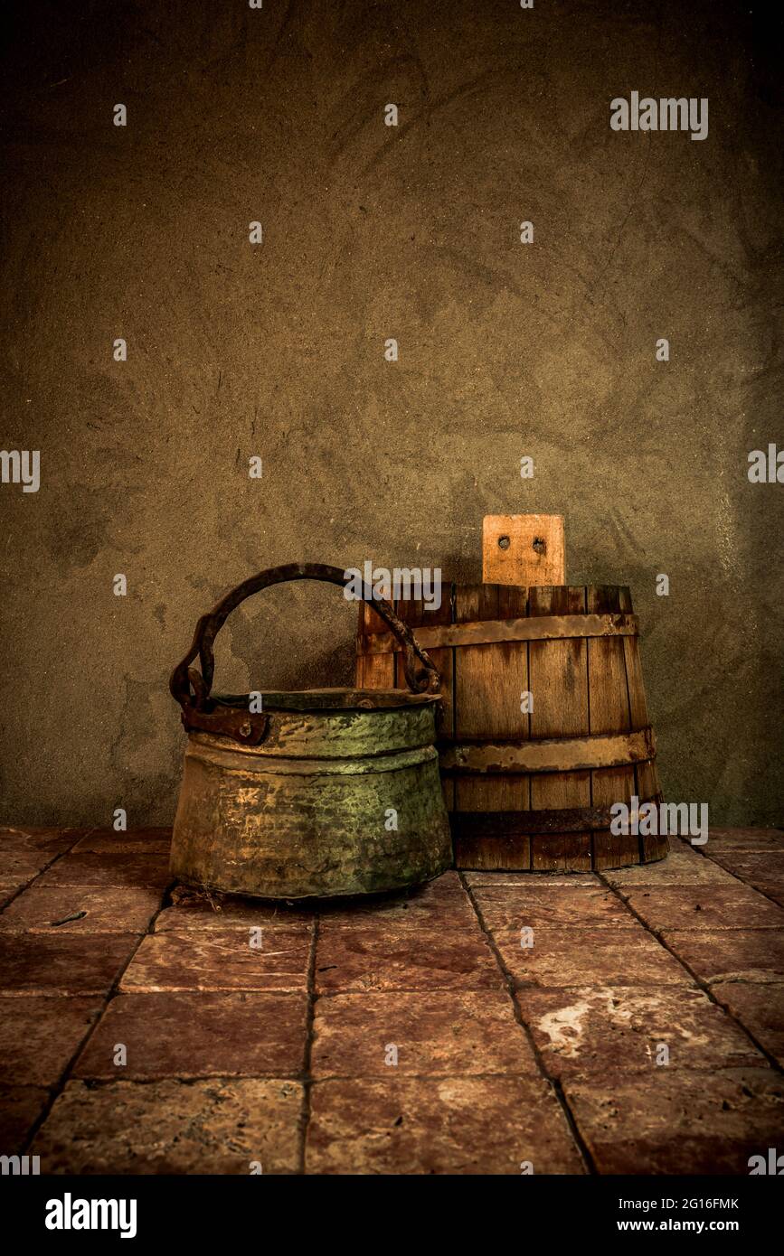 Vecchi elettrodomestici rustici in legno e ghisa su piastrelle d'epoca e pareti di cemento fondo. Foto Stock