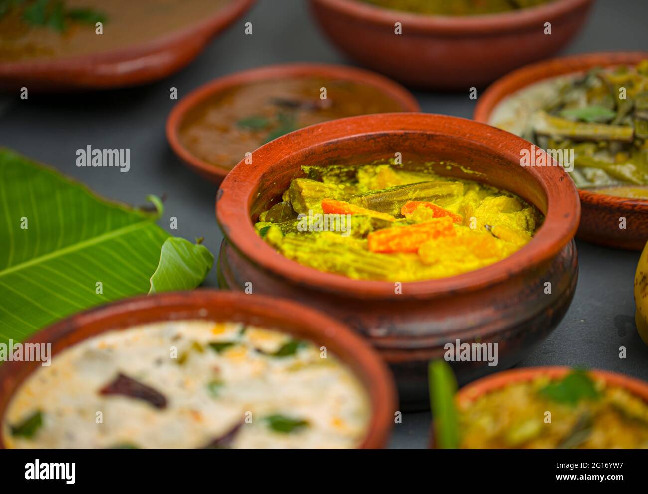 Kerala tradizionale banchetto contorni disposti su sfondo grigio, fuoco selettivo. Foto Stock