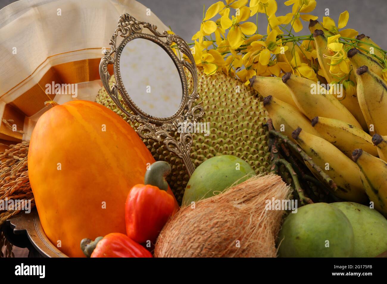 Kerala festival, rituali di Vishu festival - Vishukkani o Vishu vista, un vaso di ottone riempito di frutta, verdura, risone;specchio, fiore doccia oro Foto Stock