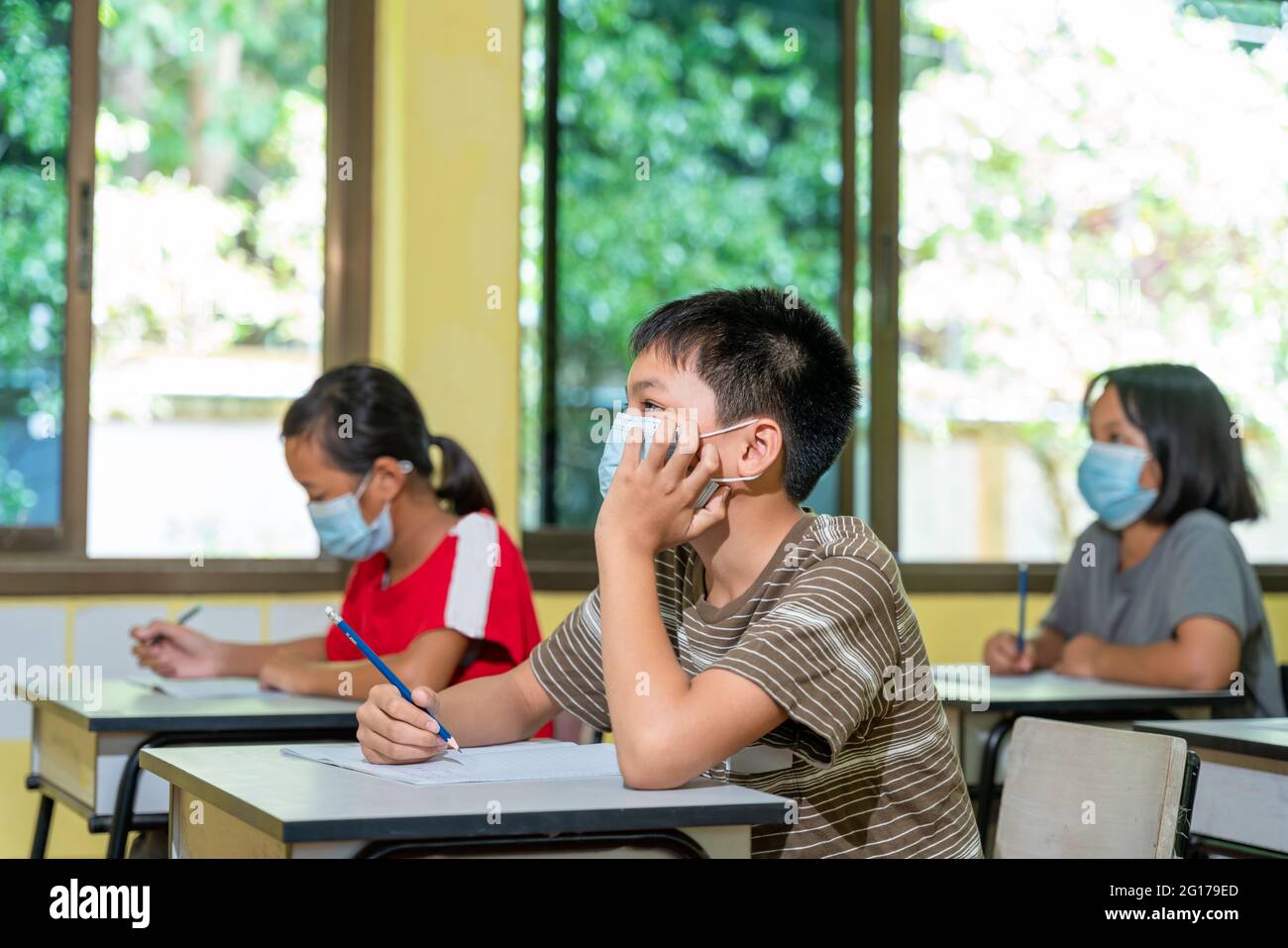 Bambini asiatici con maschera di protezione di ritorno a scuola dopo la quarantena covid-19 e il blocco. Foto Stock
