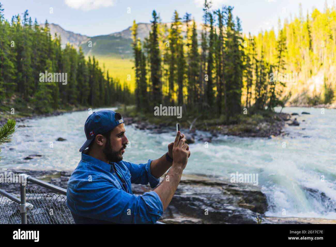 Il viaggiatore maschile visita le cascate di Sunwapta visita nelle montagne rocciose canadesi, Alberta, Canada, 2016 Foto Stock