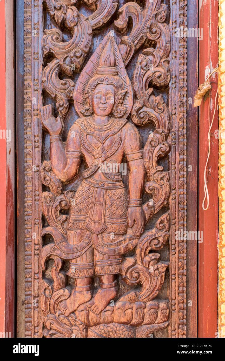 Figura scolpita nella cornice della porta di Wat Luang Pakse, tempio a Pakse, Laos Foto Stock