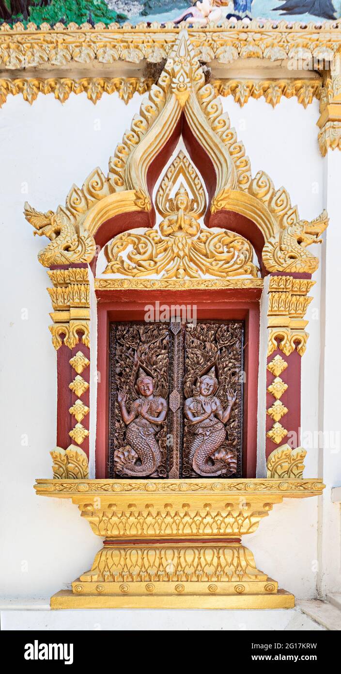 Persiane decorate sulla finestra del tempio di donne con code di pesce, Wat Luang Pakse, Pakse, Laos Foto Stock