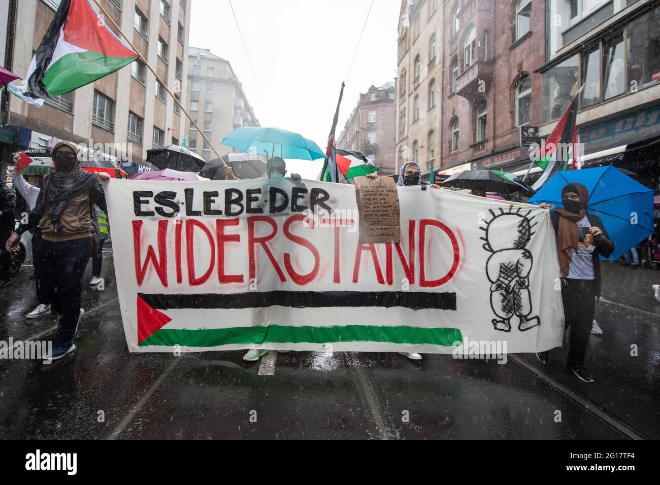 05 giugno 2021, Hessen, Francoforte sul meno: I partecipanti a una manifestazione pro-Palestina sotto lo slogan "Naksa Day, Long Live the Resistance", attraversano Francoforte in una pioggia di tipo cloudburst. La polizia ha garantito la marcia di protesta con un grande contingente. Foto: Boris Roessler/dpa Foto Stock