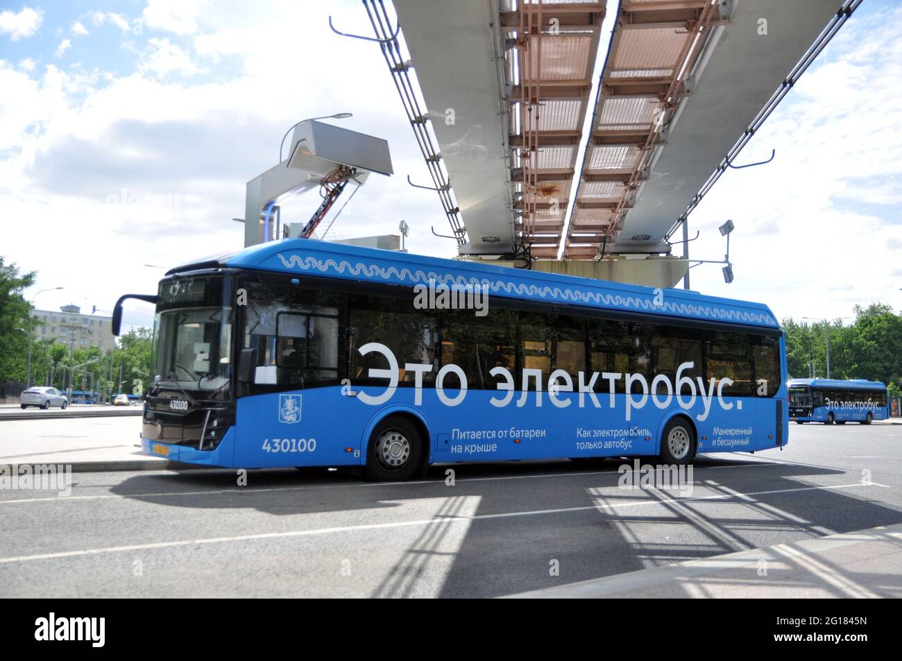 Bus elettrico alla stazione di ricarica durante la ricarica. Trasporti pubblici urbani ecologici del futuro. Foto Stock