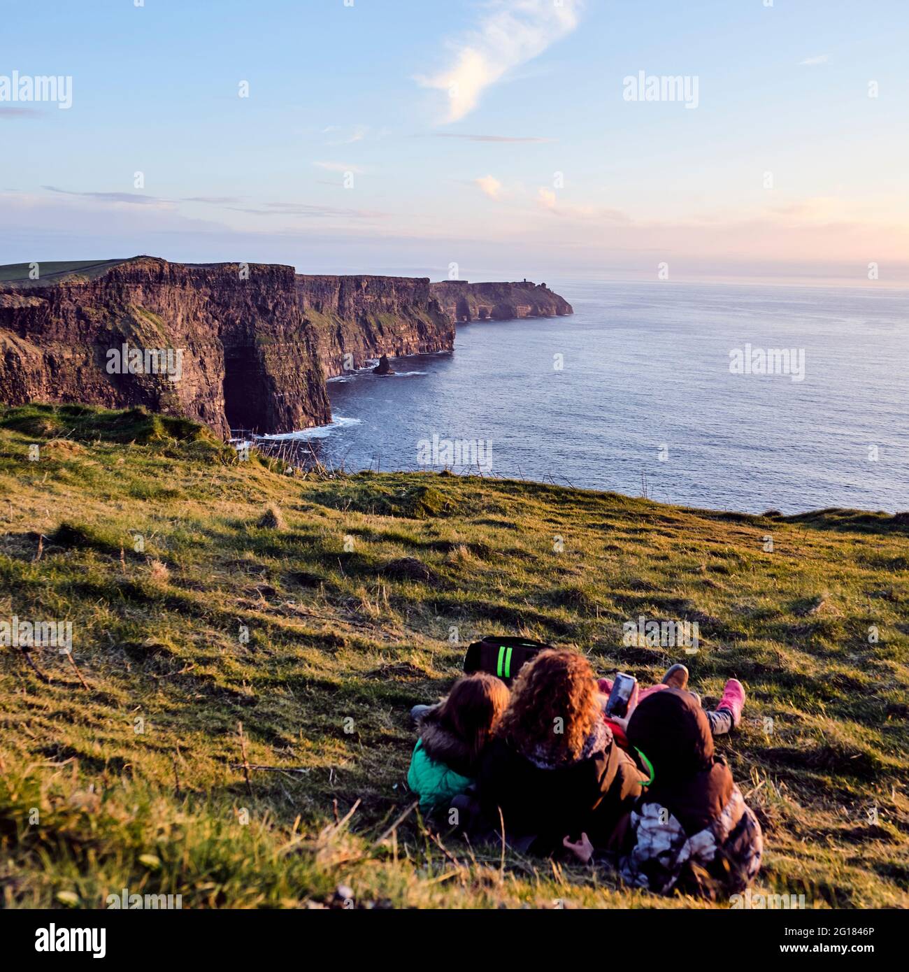 Scogliere di Moher con la famiglia observering durante il tramonto, County Clare, Irlanda, Europa 2018 Foto Stock