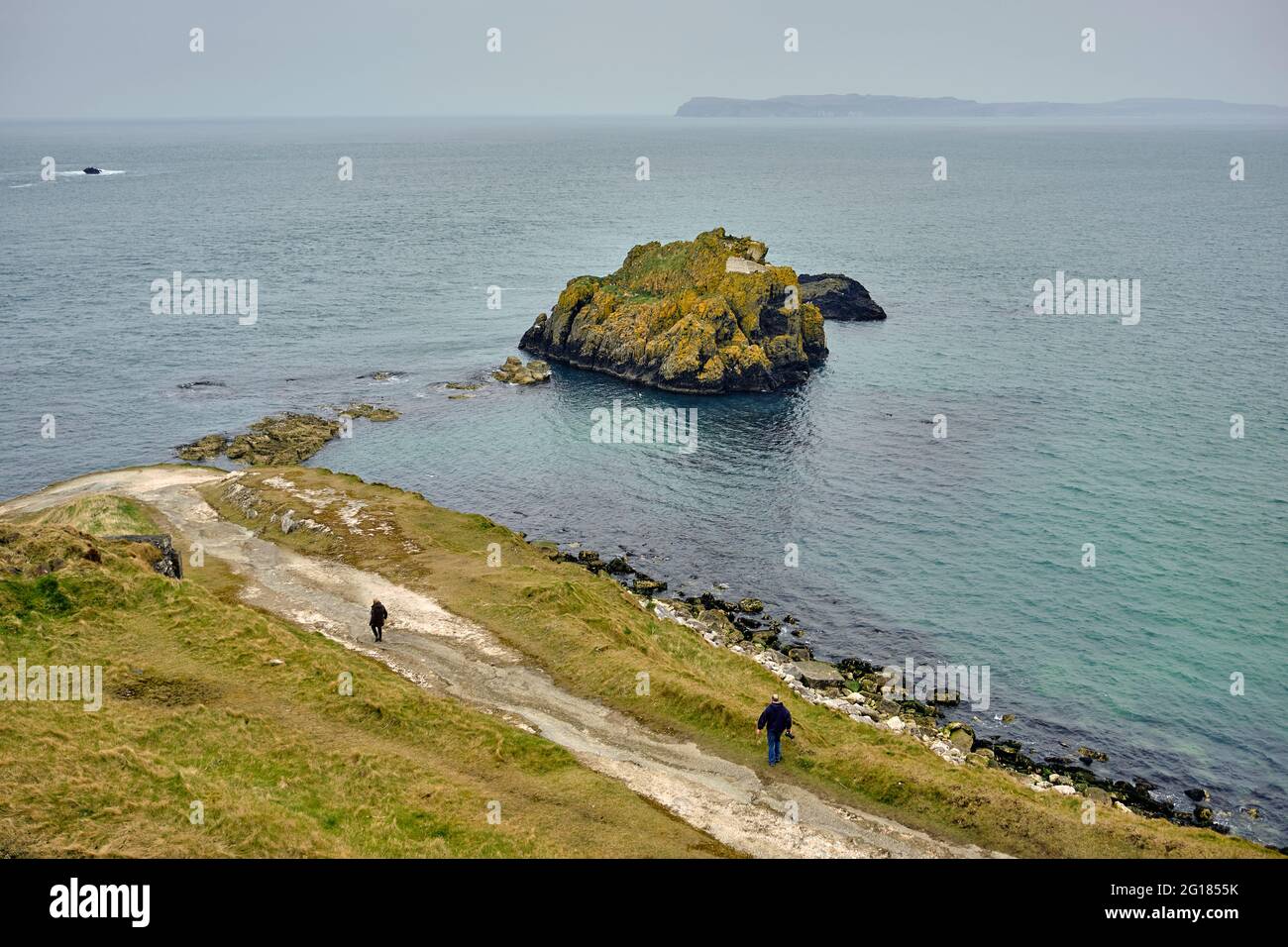 Gli escursionisti a piedi lungo la costa irregolare del Nord Oceano Atlantico, Ballycastle, Irlanda del Nord, Regno Unito, 2018 Foto Stock