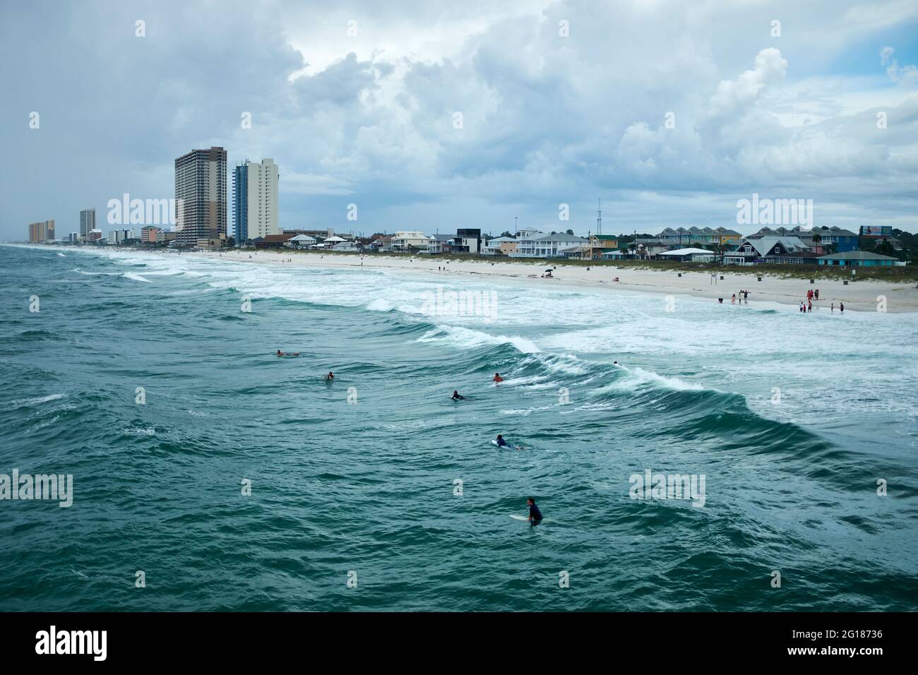 Surfers di attesa per la prossima ondata rottura con gli alberghi dietro, Panama City Beach, Florida, USA, 2019 Foto Stock