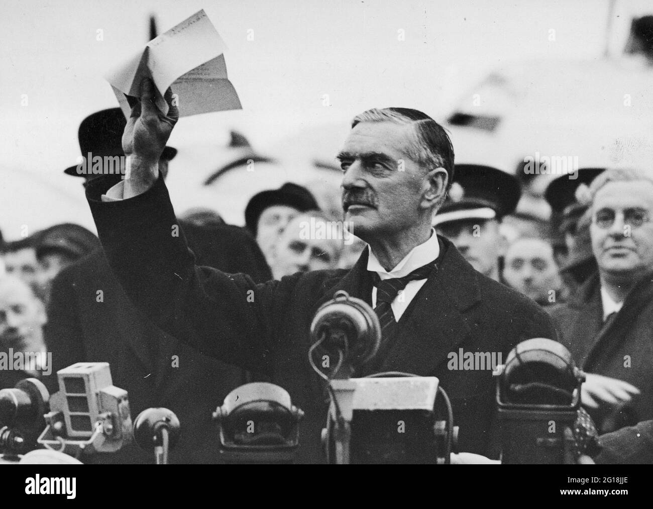 L'accordo di Monaco del 1938: Il primo ministro britannico Neville Chamberlain ondeggia l'accordo di Monaco con le parole "Pace nel nostro tempo" all'aeroporto di Heston Foto Stock