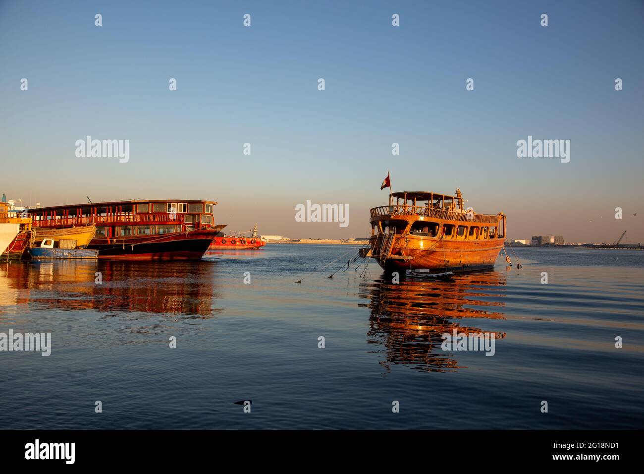 Navi da carico in legno bagnate dalla luce solare dorata sul torrente Deira. Dubai, Emirati Arabi Uniti, 12.12.2018 Foto Stock