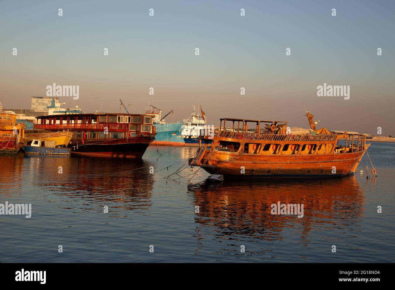 Navi da carico in legno bagnate dalla luce solare dorata sul torrente Deira. Dubai, Emirati Arabi Uniti, 12.12.2018 Foto Stock
