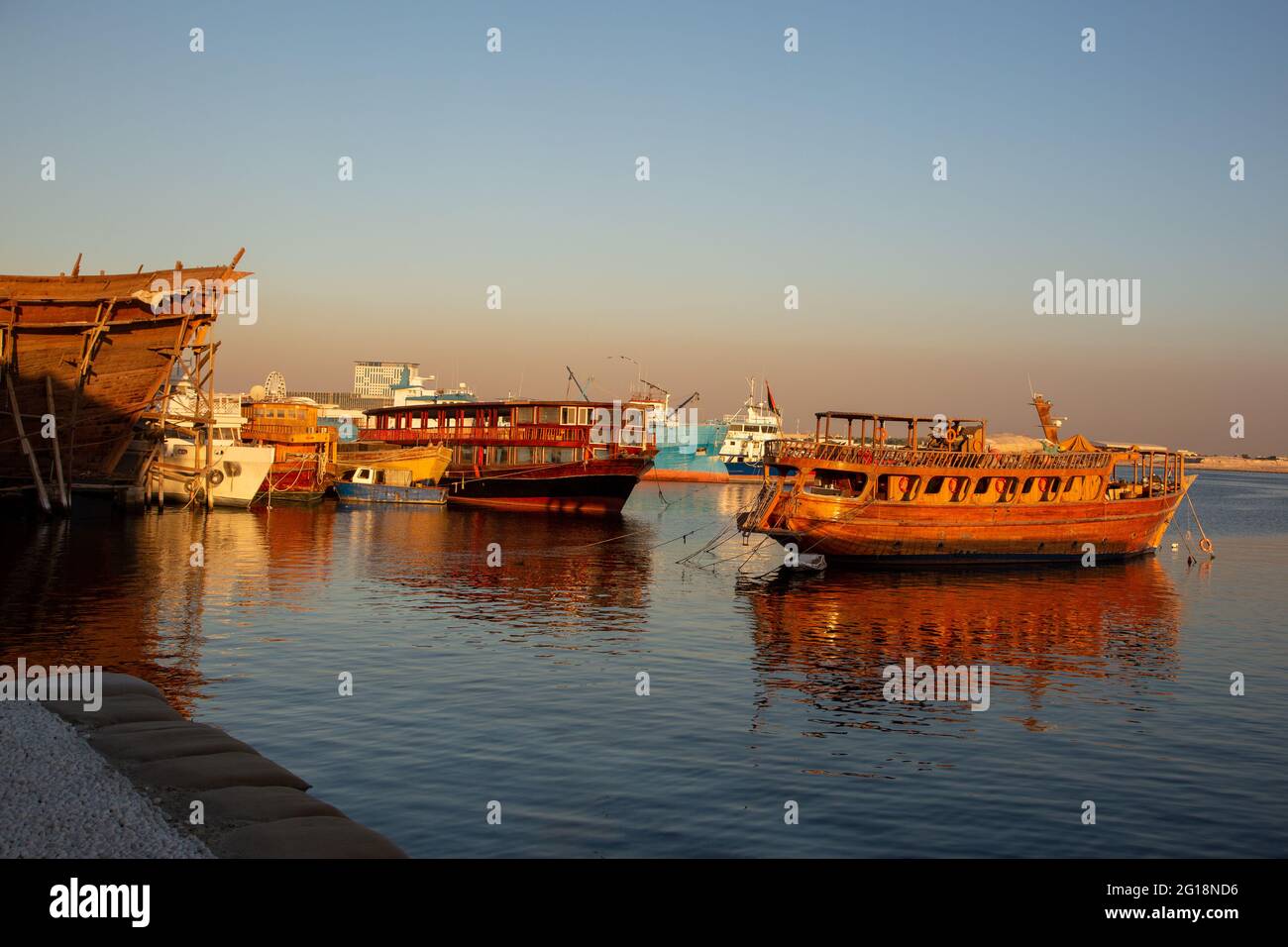 Navi da carico in legno bagnate dalla luce solare dorata sul torrente Deira. Dubai, Emirati Arabi Uniti, 12.12.2018 Foto Stock