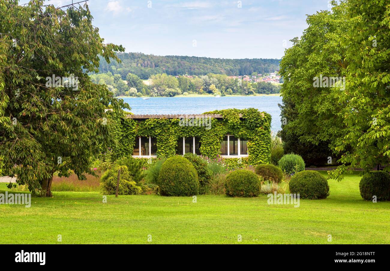 Progettazione paesaggistica con piante e fiori in casa a Reichenau Island, Germania. Bella casa giardino paesaggistico con vista sul lago di Costanza (Bodensee). SC Foto Stock