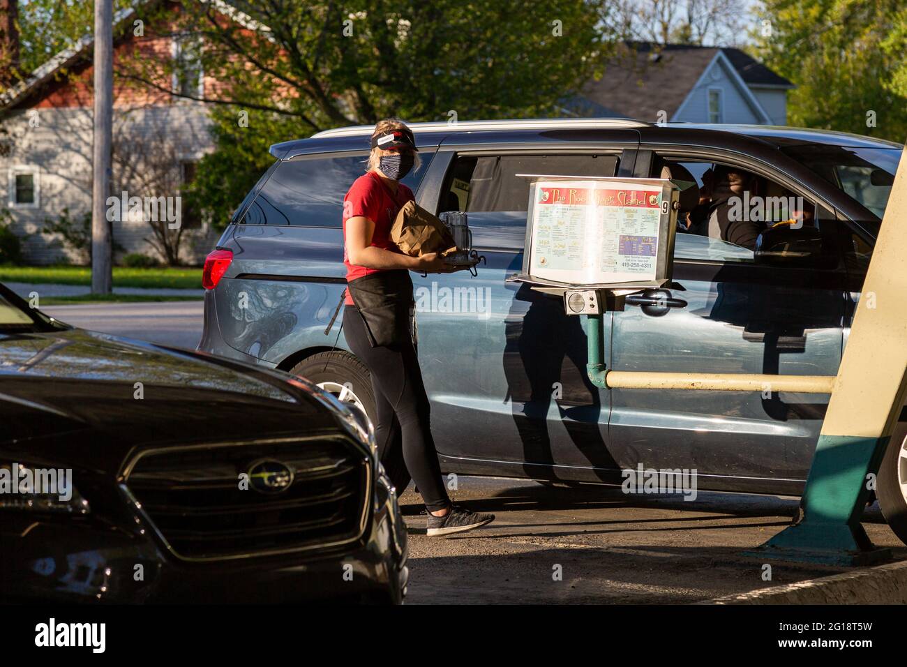 Un carhop porta un ordine di cibo su un minivan blu al Root Beer Stand di Anversa, Ohio, USA. Foto Stock