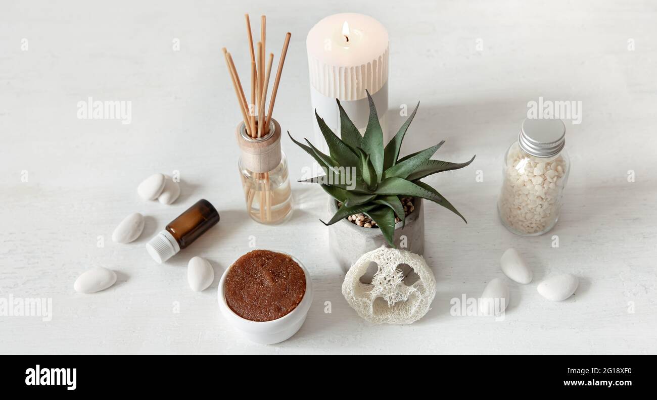 Composizione accogliente con bastoncini d'incenso per profumazione interna e prodotti per la salute e la bellezza. Foto Stock