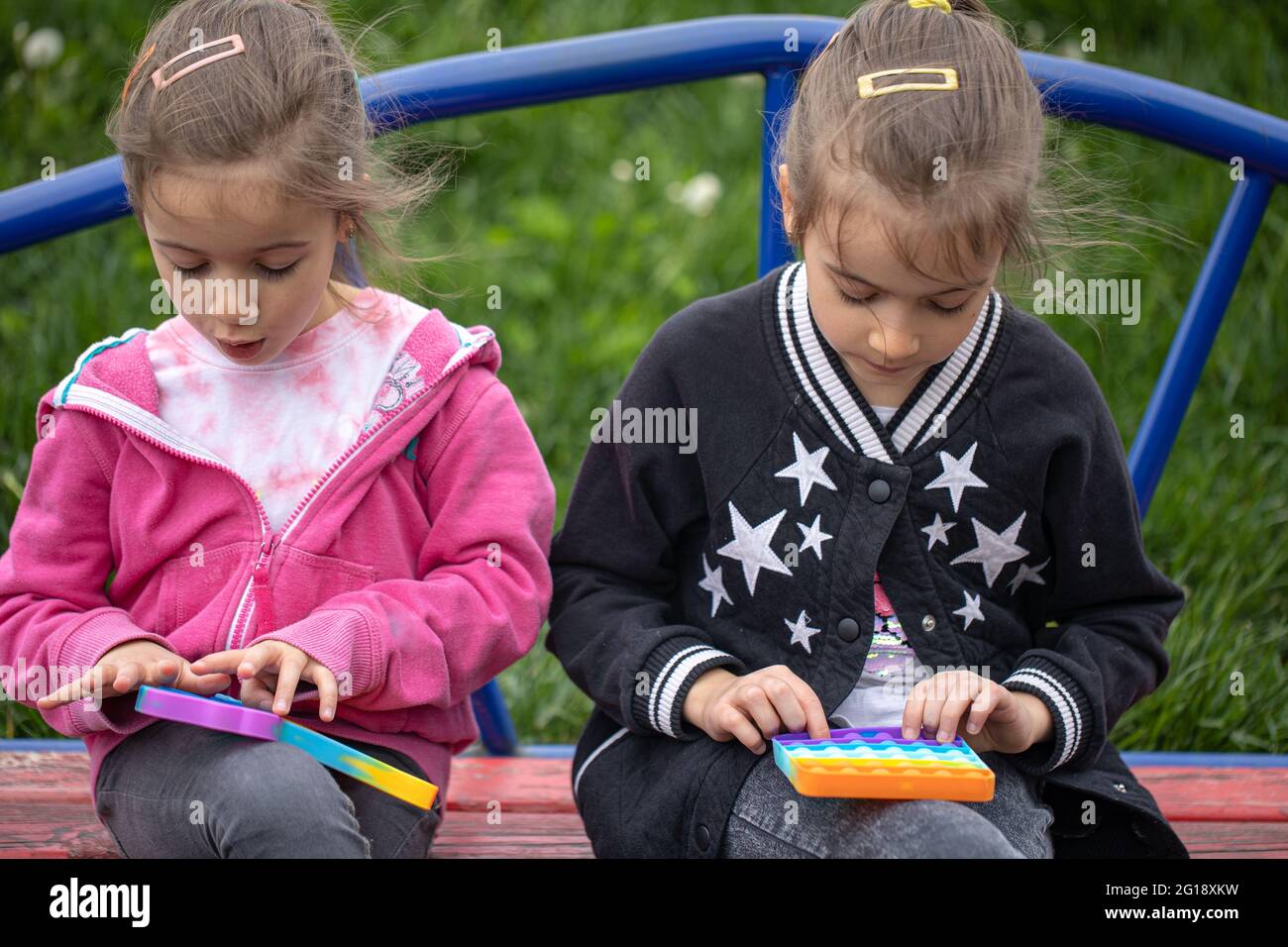 I bambini che giocano con un popolare giocattolo pop esso, tenere nelle loro mani anti-stress, gioco di silicone. Foto Stock