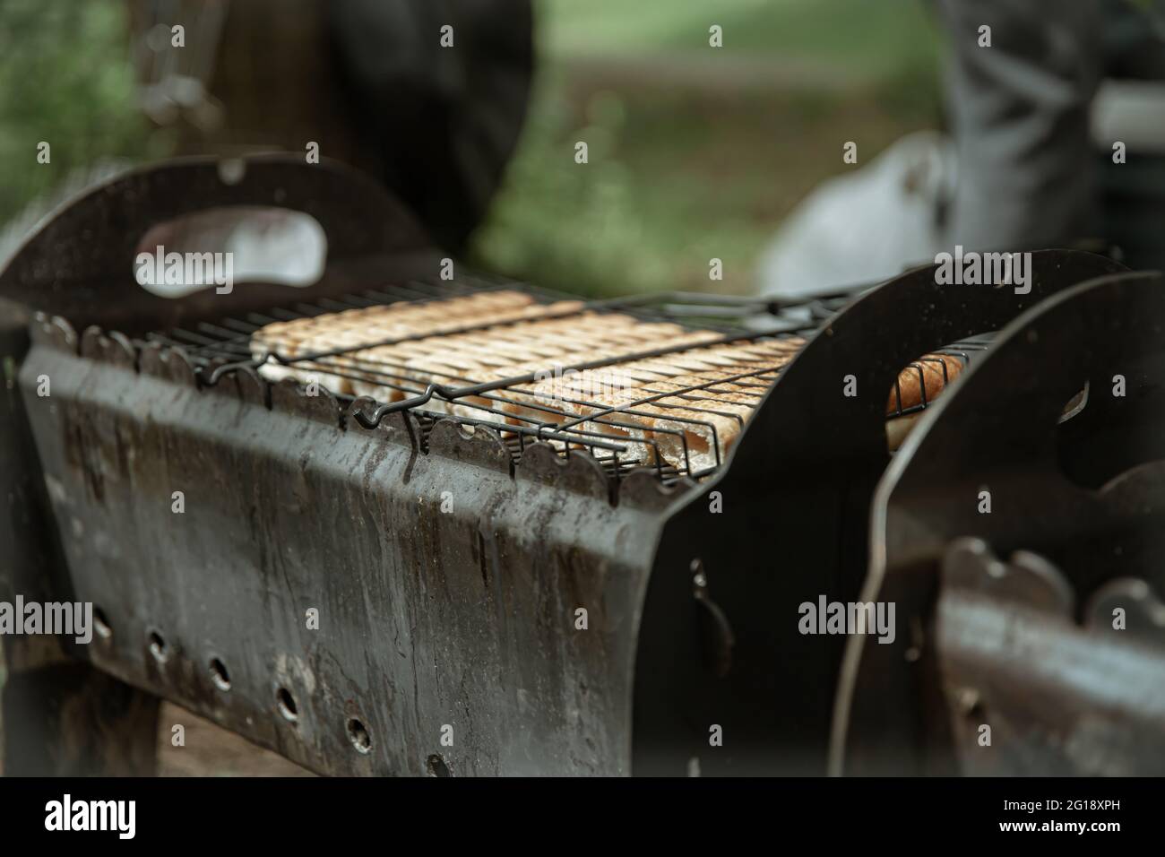 Primo piano di ciambelle di cani caldi fritte in una griglia sulla griglia. Foto Stock