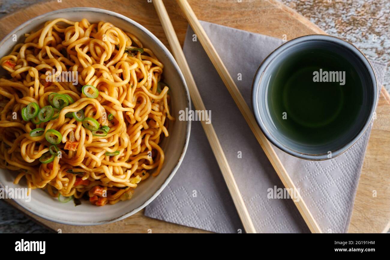 Cibo giapponese, tagliatelle di verdure in salsa Teriyaki servite in una ciotola con chopsticks sul lato. Foto Stock