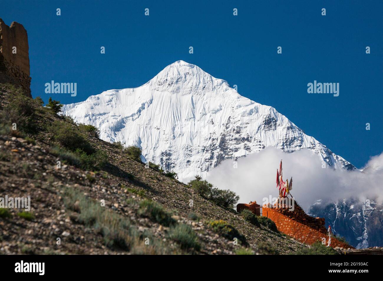 Bandiere buddiste di preghiera che scagliano sotto Nilgiri Nord (7061 m), dal sentiero di Mustang vicino a Kagbeni, Mustang, Nepal. Foto Stock