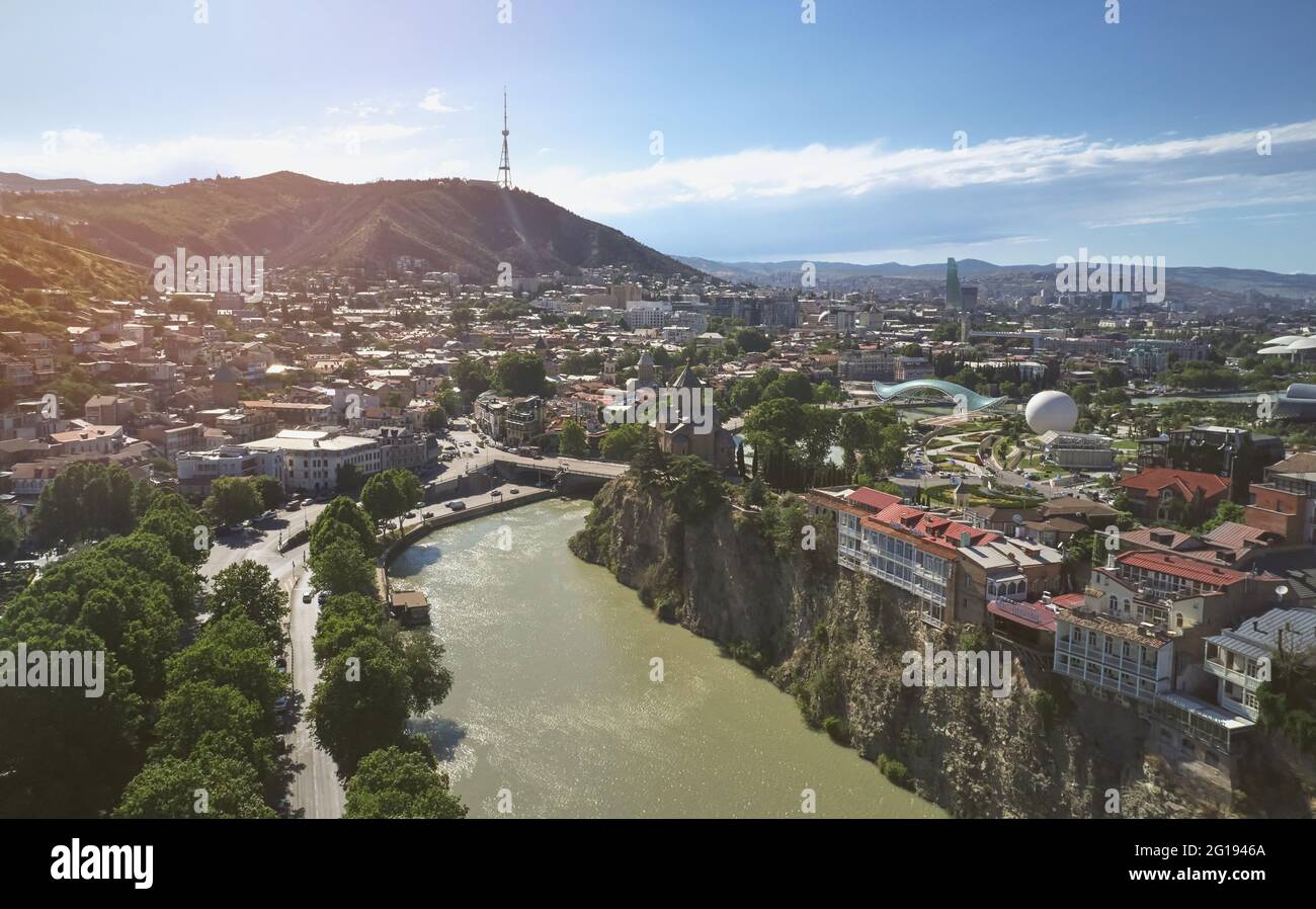 Paesaggio urbano di Tbilisi con vista aerea del drone del fiume Kura in una giornata di sole luminoso Foto Stock