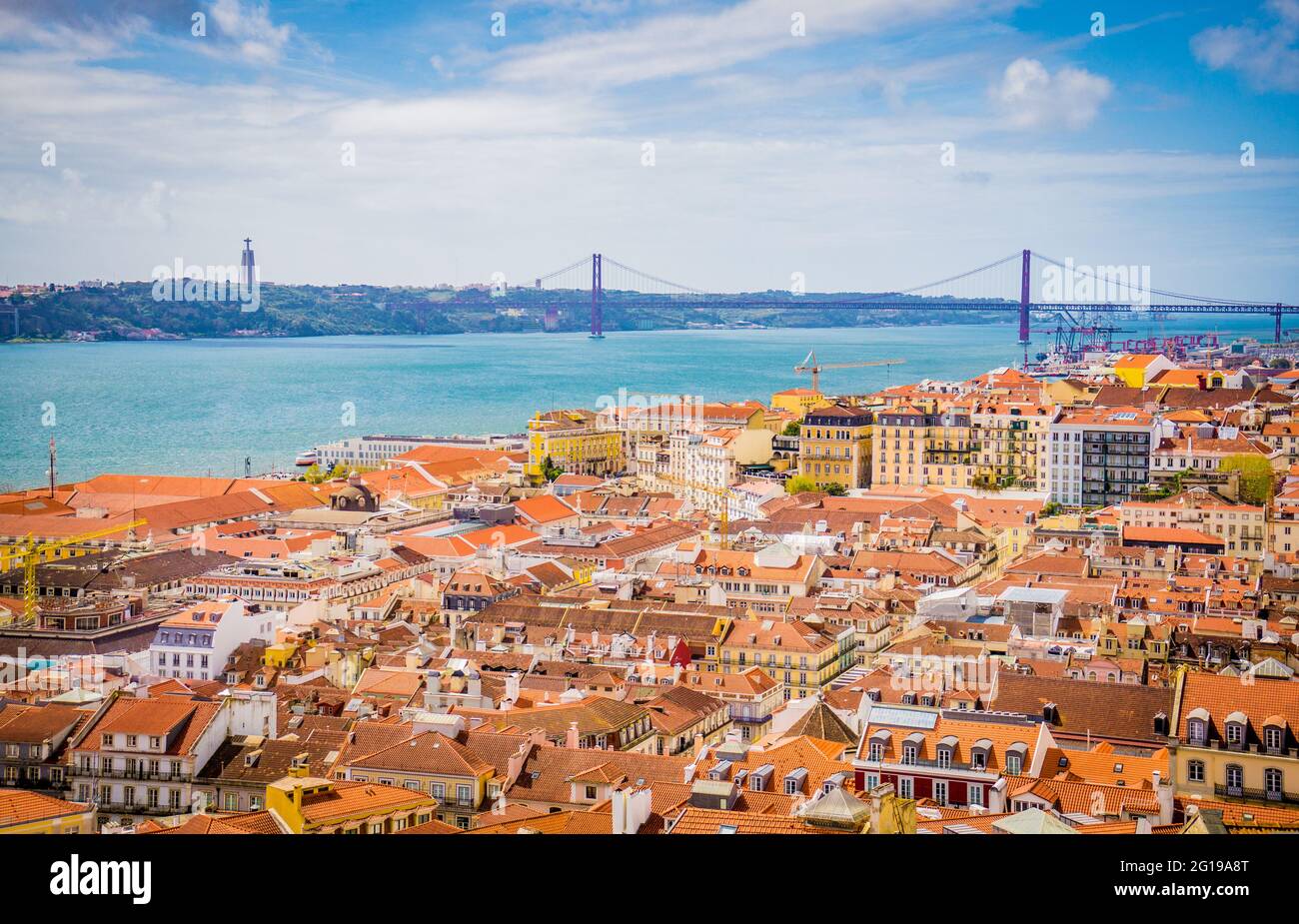 Vista aerea panoramica della vecchia città tradizionale di Lisbona con tetti arancioni e il Ponte del 25 aprile dal Castello di Sao Jorge, Portogallo. Foto Stock